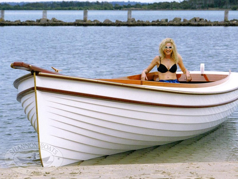 Pin Wooden Boats On River Bank With Landscape In Background Wallpaper 